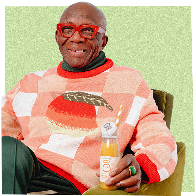 Mann trägt einen grossen Strickpullover und trinkt einen innocent Smoothie